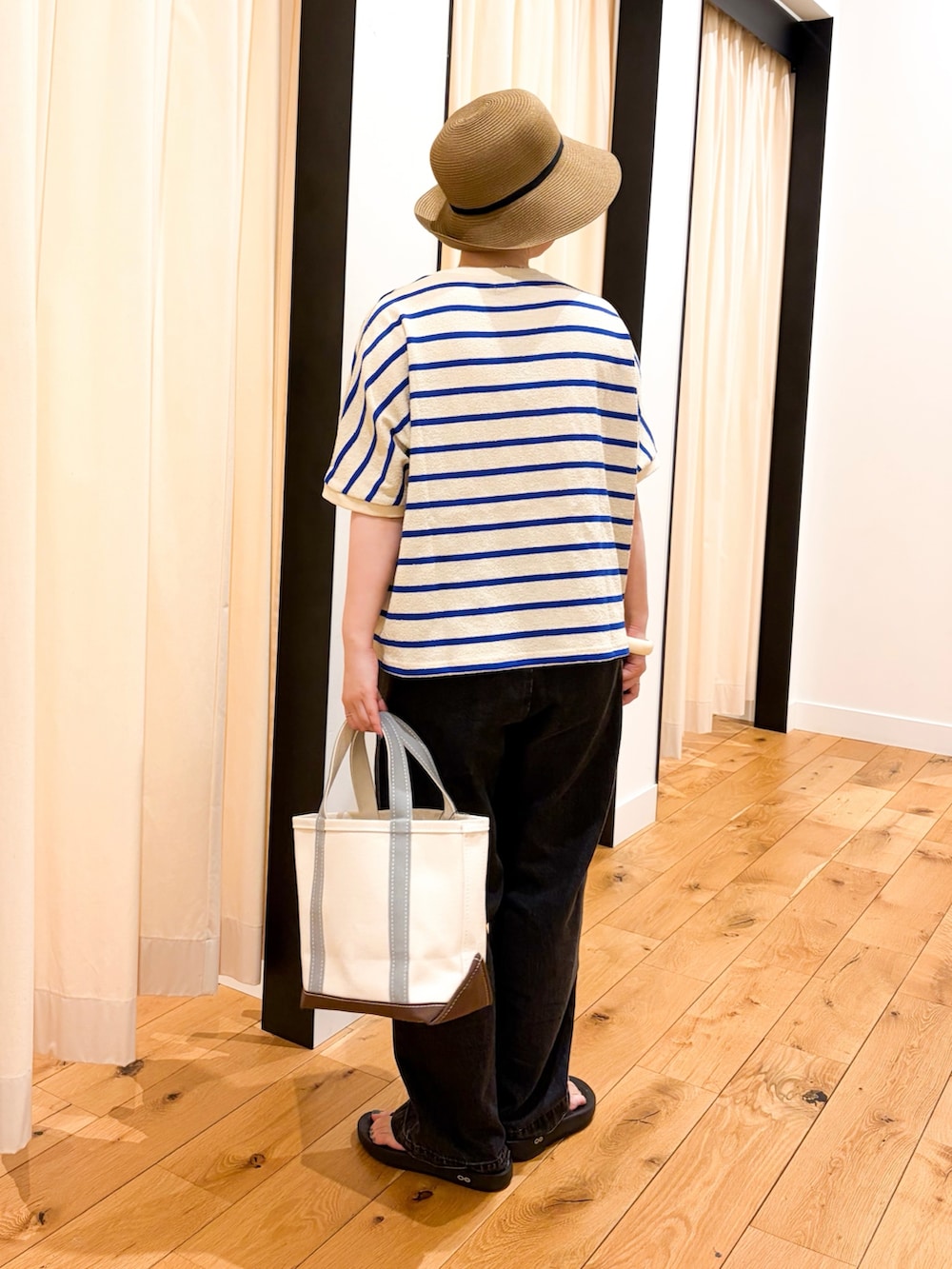ブルー系のTシャツ/カットソー、グリーン系のトートバッグ、ブラック系のデニムパンツを着用したレディースの夏コーディネートの3枚目の写真