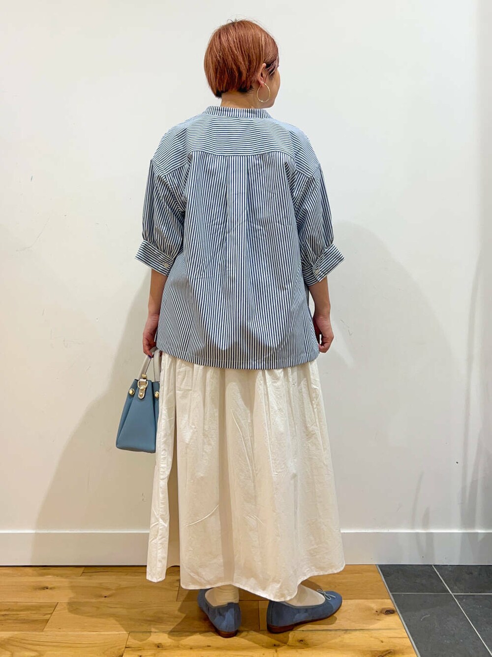 ブルー系のトートバッグ、ブルー系のバレエシューズ、ブルー系のTシャツ/カットソーを着用したレディースの夏コーディネートの3枚目の写真