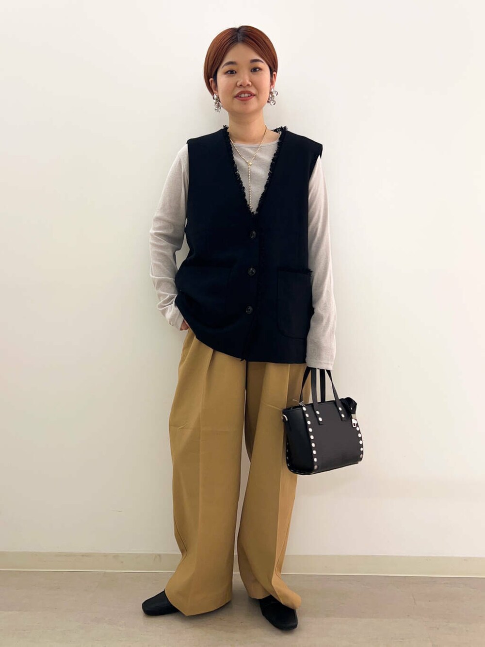 ブラック系のドレスシューズ、ブラック系のショルダーバッグ、ベージュ系のTシャツ/カットソーを着用したレディースの夏コーディネートの2枚目の写真