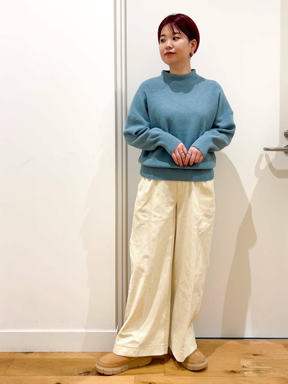 ホワイト系のダウンジャケット/コート、ブルー系のニット/セーター、ホワイト系のその他パンツを着用したレディースの秋コーディネートの4枚目の写真