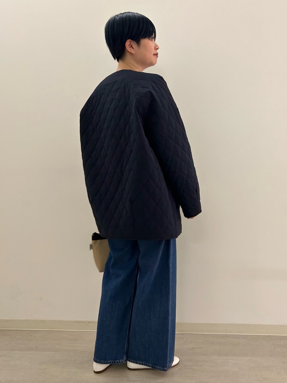 ホワイト系のパンプス、ブルー系のダウンジャケット/コート、ベージュ系のショルダーバッグを着用したレディースの冬コーディネートの3枚目の写真