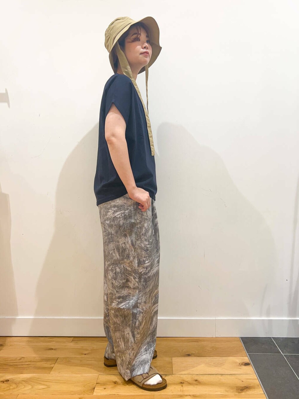 ブルー系のTシャツ/カットソー、ゴールド系のハンドバッグ、ベージュ系のサンダルを着用したレディースの夏コーディネートの2枚目の写真