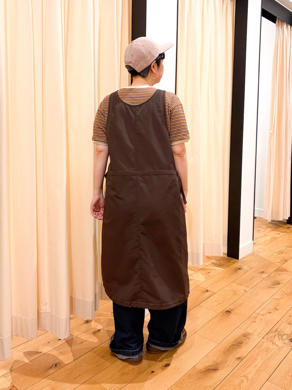 ブラウン系のTシャツ/カットソー、ブラウン系のワンピース、ブルー系のデニムパンツを着用したレディースの春コーディネートの2枚目の写真