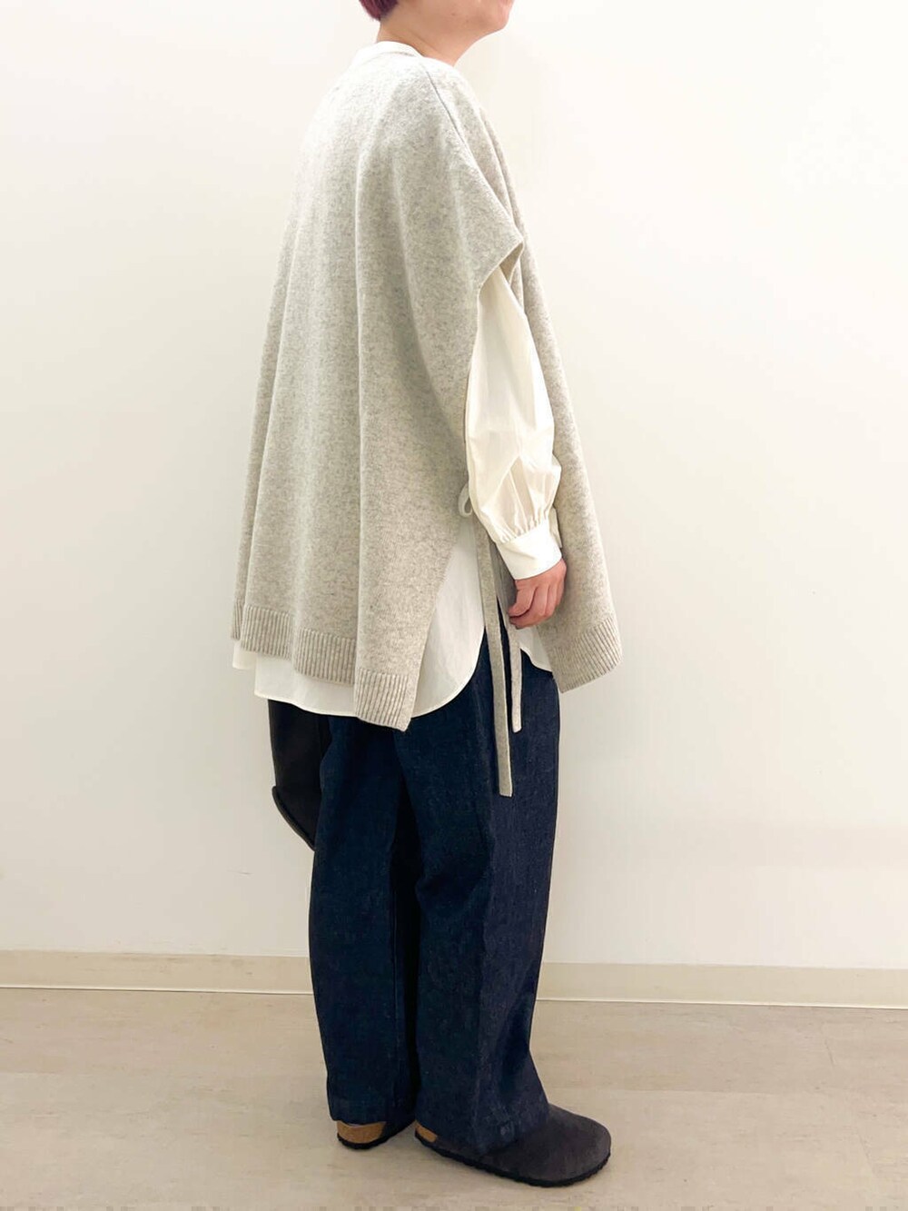 ブルー系のデニムパンツ、ブラウン系のトートバッグ、ホワイト系のシャツ/ブラウスを着用したレディースの冬コーディネートの3枚目の写真