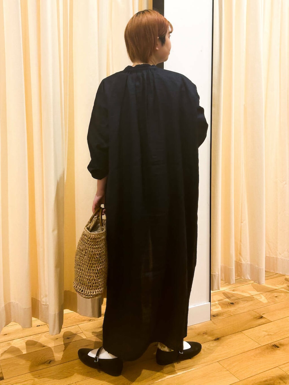 ブルー系のワンピース、ブラック系のパンプス、ベージュ系のトートバッグを着用したレディースの春コーディネートの4枚目の写真