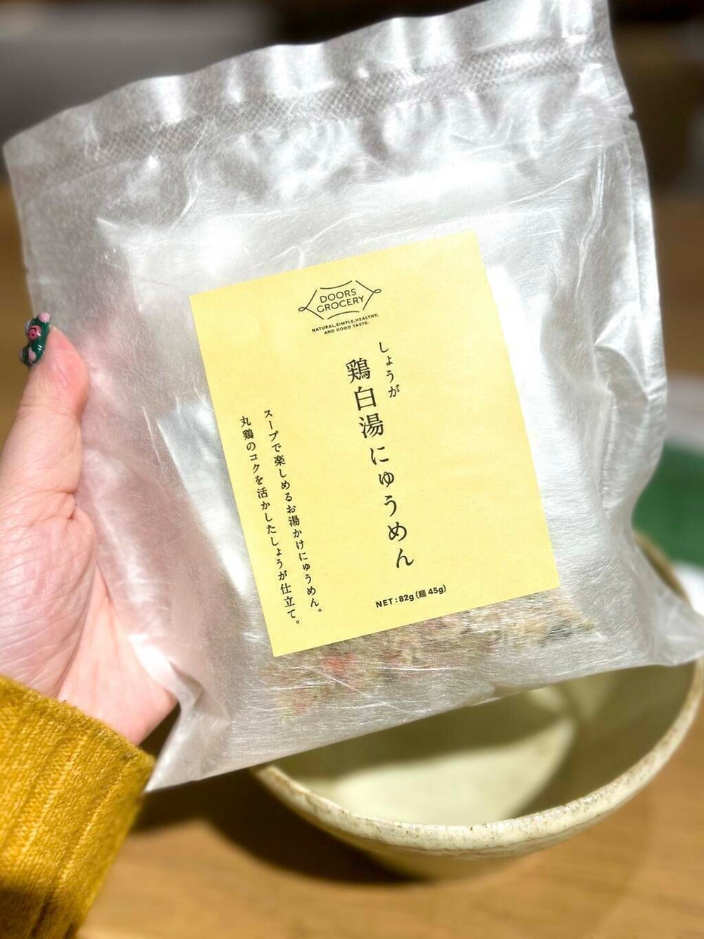 イエロー系のニット/セーター、ホワイト系の食器、その他の食器を着用したレディースの冬コーディネートの3枚目の写真