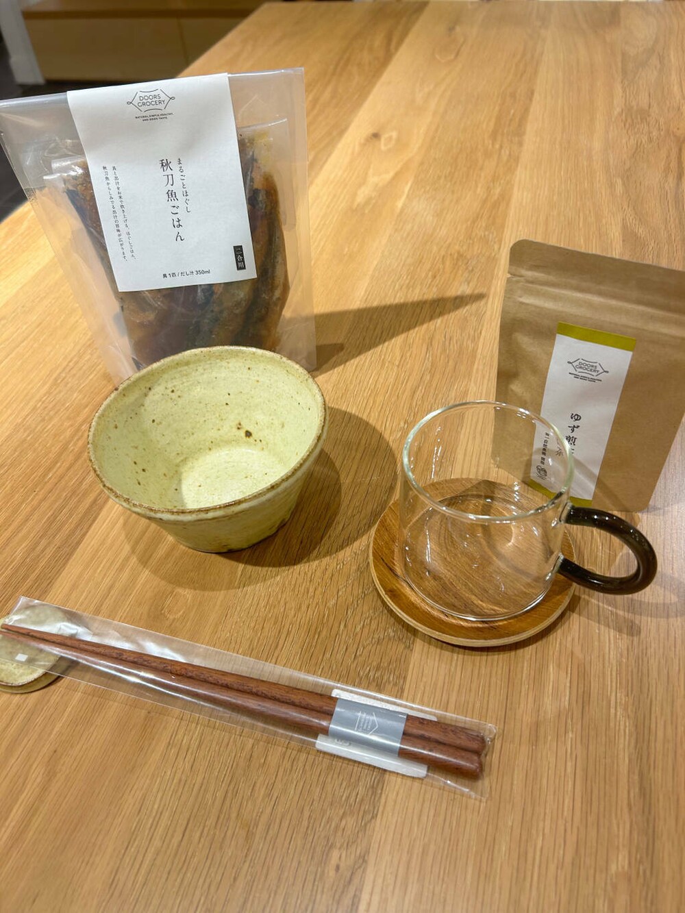 ブルー系のニット/セーター、グレー系のその他雑貨、ゴールド系のイヤリングを着用したレディースの秋コーディネートの2枚目の写真