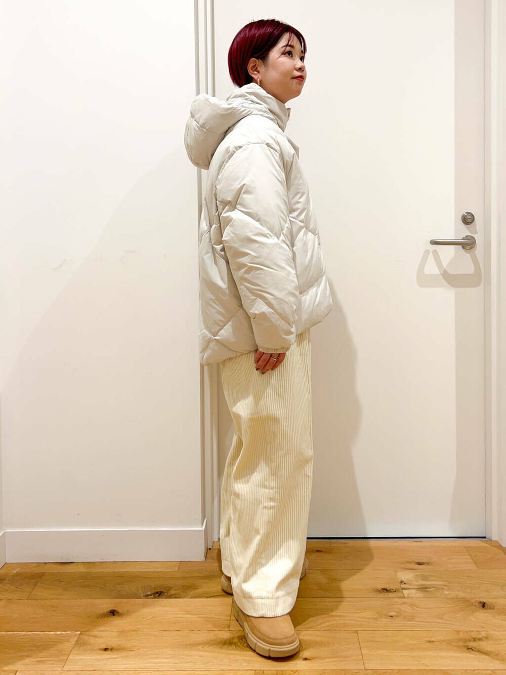 ホワイト系のダウンジャケット/コート、ブルー系のニット/セーター、ホワイト系のその他パンツを着用したレディースの秋コーディネートの3枚目の写真