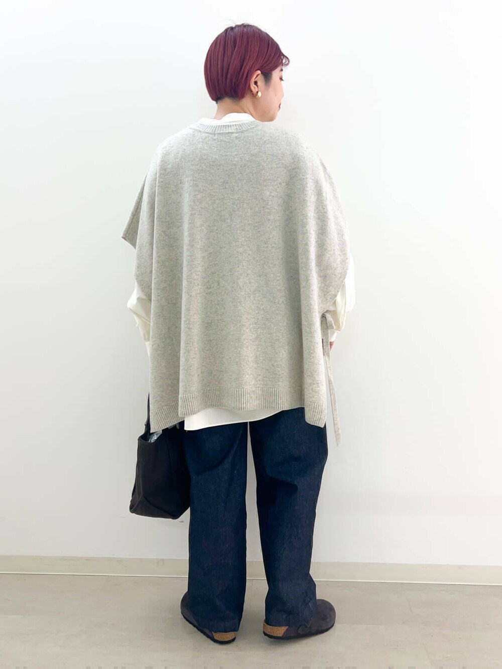 ブルー系のデニムパンツ、ブラウン系のトートバッグ、ホワイト系のシャツ/ブラウスを着用したレディースの冬コーディネートの2枚目の写真