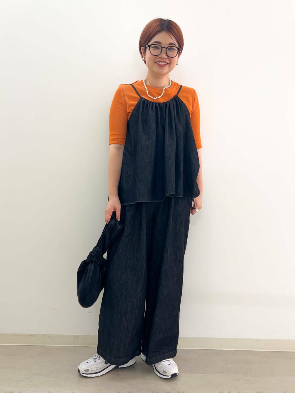 ブラック系のハンドバッグ、ブラック系のサロペット/オーバーオール、グレー系のTシャツ/カットソーを着用したレディースの秋コーディネートの2枚目の写真