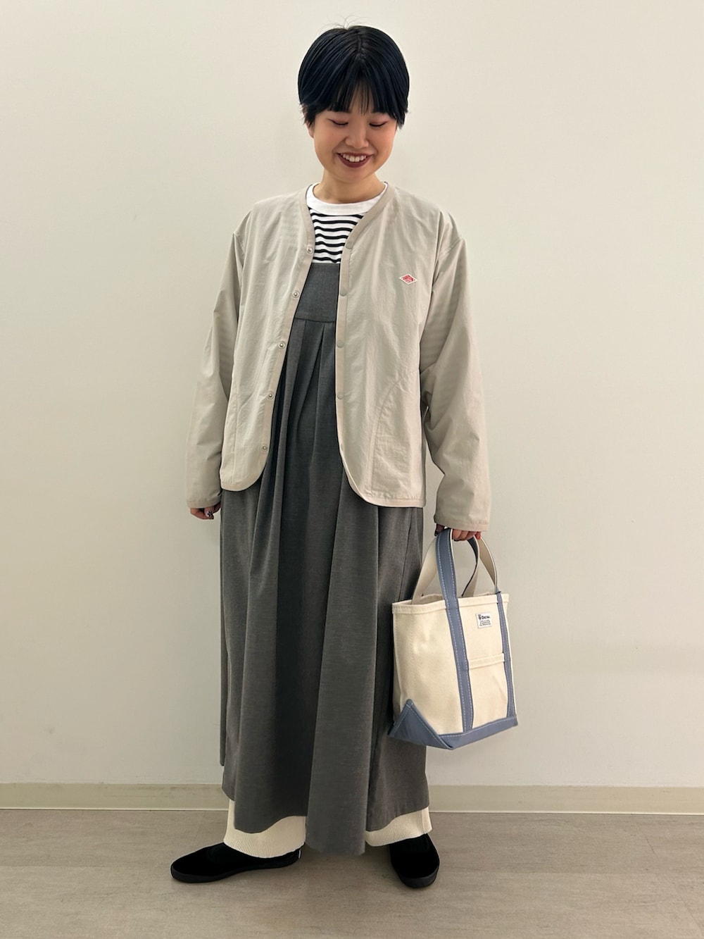 グレー系のワンピース、ブルー系のトートバッグを着用したレディースの春コーディネートの2枚目の写真