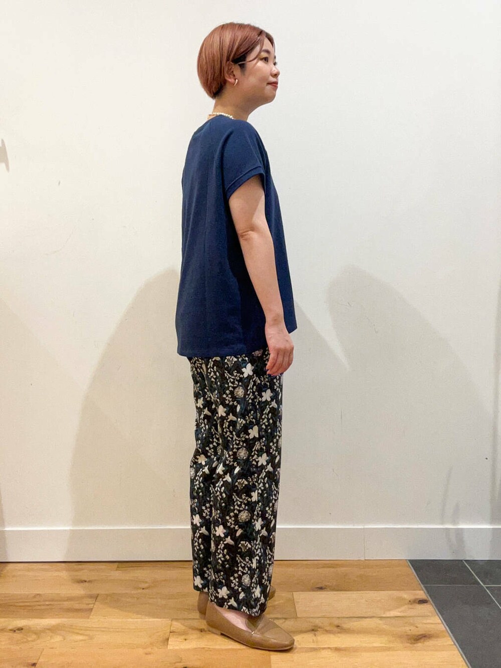 ベージュ系のローファー、ブラウン系のハンドバッグ、ブルー系のTシャツ/カットソーを着用したレディースの夏コーディネートの3枚目の写真