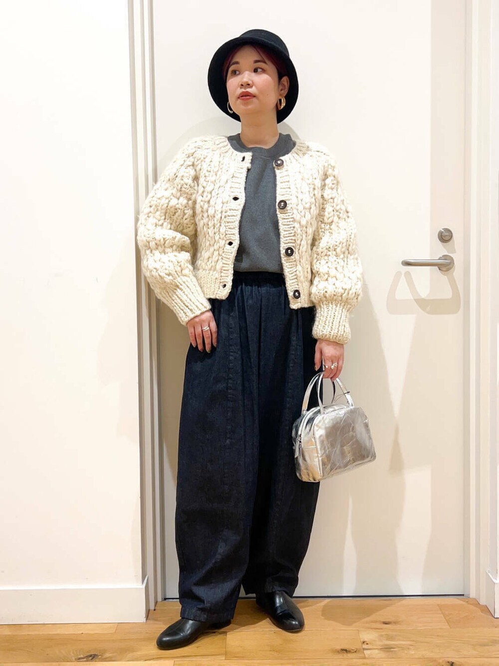 ホワイト系のカーディガン/ボレロ、ブルー系のデニムパンツ、ブラック系のその他シューズを着用したレディースの冬コーディネートの2枚目の写真