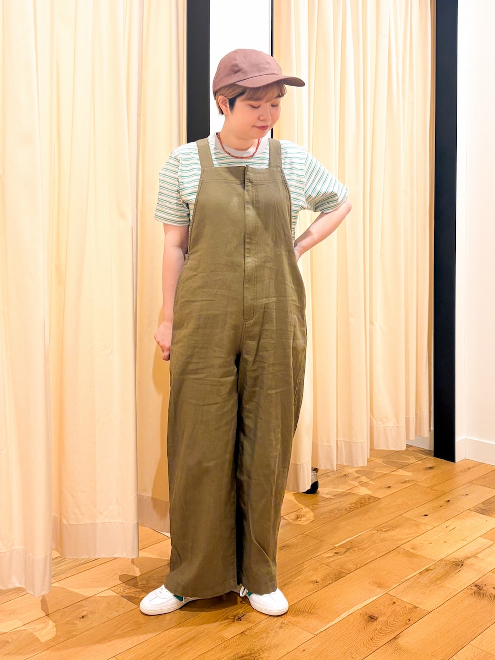 ホワイト系のスニーカー、グリーン系のサロペット/オーバーオール、ブラック系のショルダーバッグを着用したレディースの春コーディネートの3枚目の写真