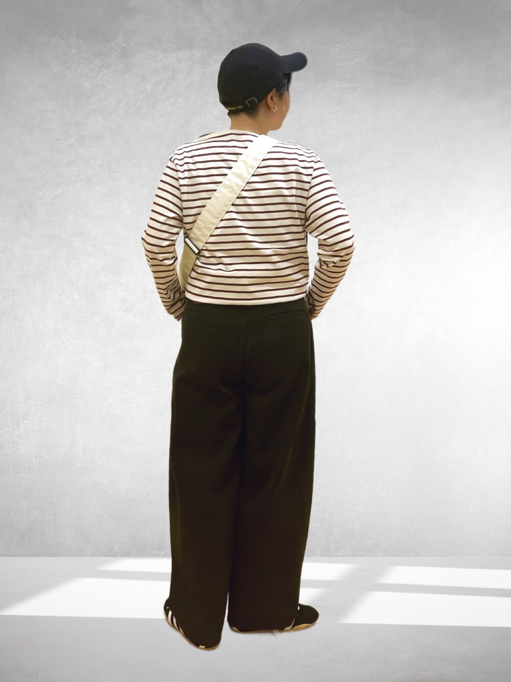 グレー系のその他パンツ、レッド系のTシャツ/カットソー、ブラック系のスニーカーを着用したレディースの秋コーディネートの2枚目の写真