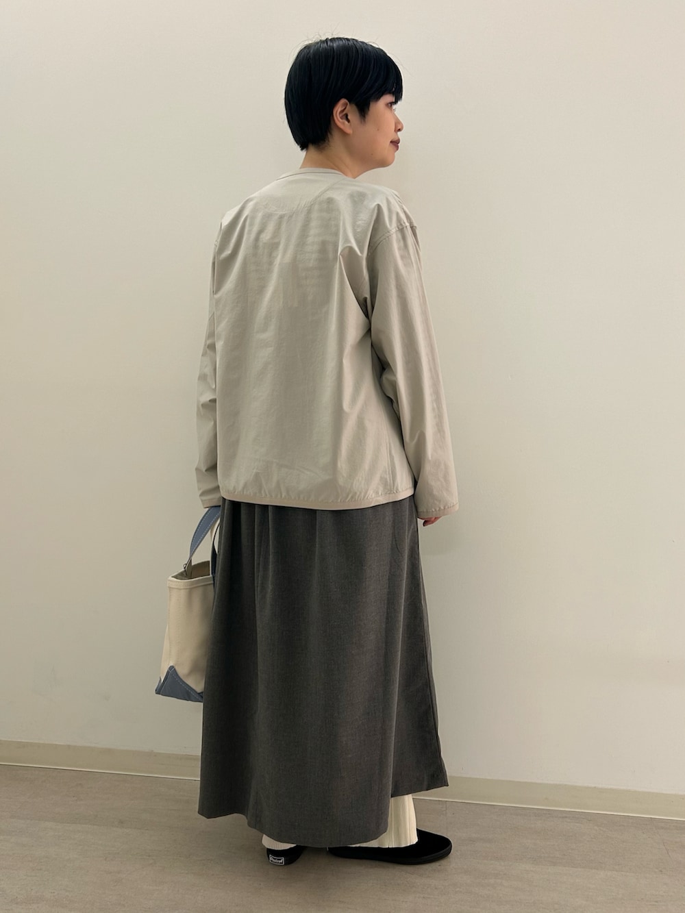 グレー系のワンピース、ブルー系のトートバッグを着用したレディースの春コーディネートの3枚目の写真