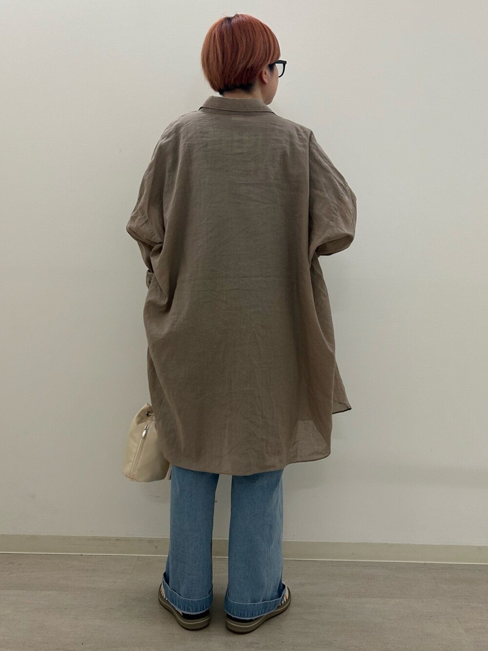 ブルー系のサロペット/オーバーオール、ベージュ系のシャツ/ブラウス、ホワイト系のサンダルを着用したレディースの春コーディネートの3枚目の写真