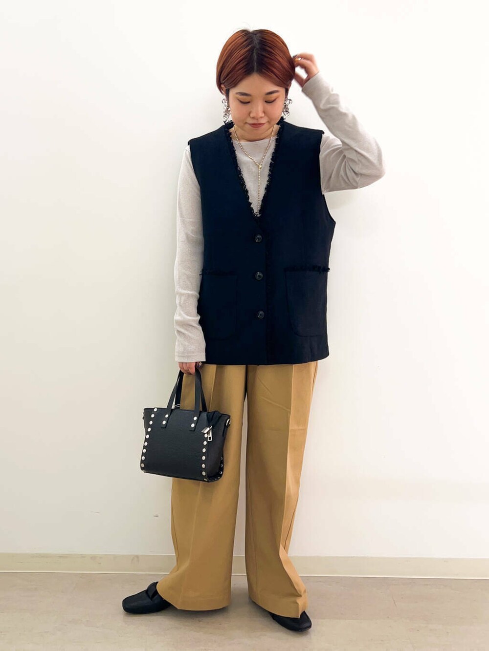 ブラック系のドレスシューズ、ブラック系のショルダーバッグ、ベージュ系のTシャツ/カットソーを着用したレディースの夏コーディネートの3枚目の写真