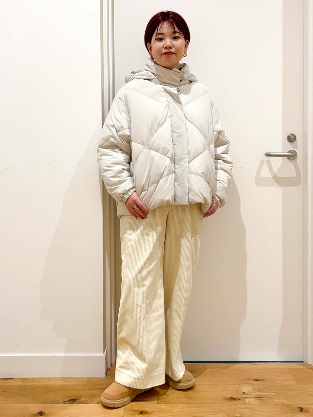 ホワイト系のダウンジャケット/コート、ブルー系のニット/セーター、ホワイト系のその他パンツを着用したレディースの秋コーディネートの2枚目の写真