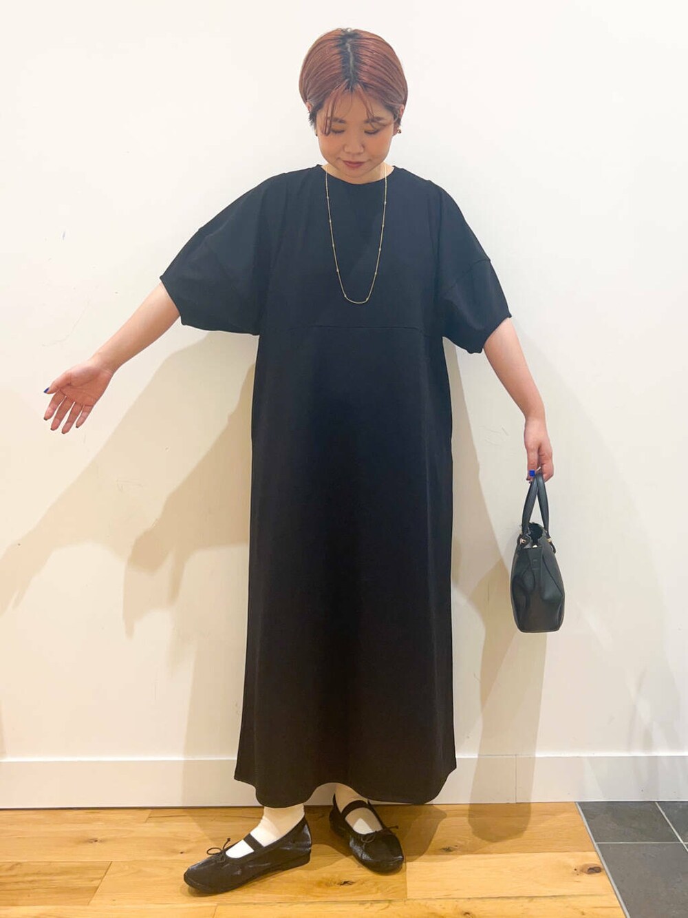 ブラック系のワンピース、ブラック系のバレエシューズ、ブラック系のショルダーバッグを着用したレディースの夏コーディネートの2枚目の写真