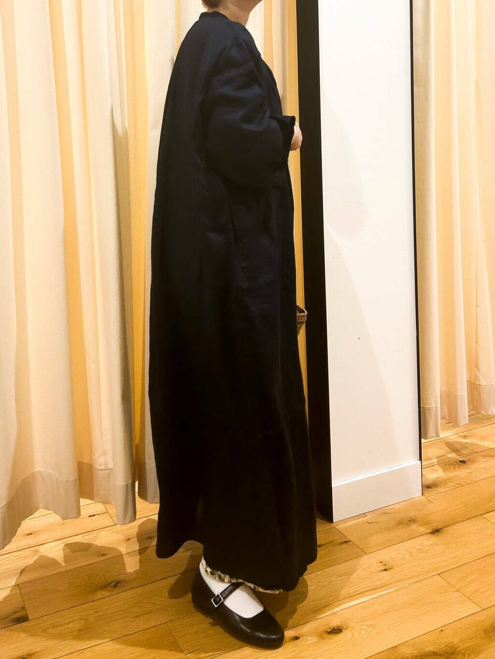 ブルー系のワンピース、ブラック系のパンプス、ベージュ系のトートバッグを着用したレディースの春コーディネートの6枚目の写真