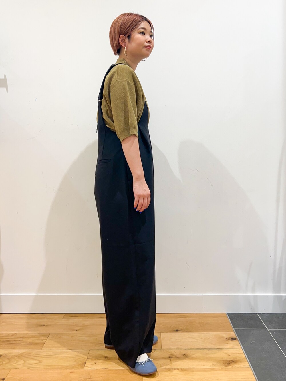 ブルー系のサロペット/オーバーオール、グリーン系のニット/セーター、ブラック系のハンドバッグを着用したレディースの夏コーディネートの3枚目の写真