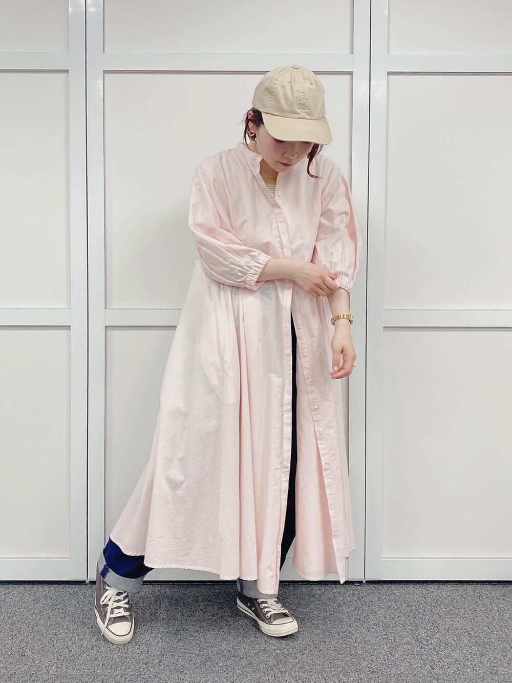 ピンク系のワンピース、ブラウン系のスニーカー、ベージュ系のキャップを着用したレディースの春コーディネートの2枚目の写真