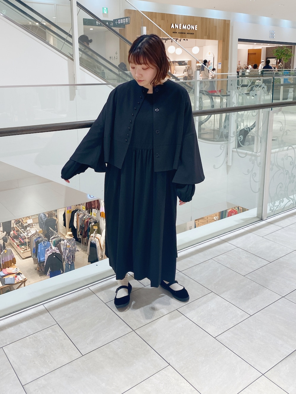 ブラック系のノーカラージャケット、ブラック系のワンピース、ブラック系のバレエシューズを着用したレディースの冬コーディネートの2枚目の写真