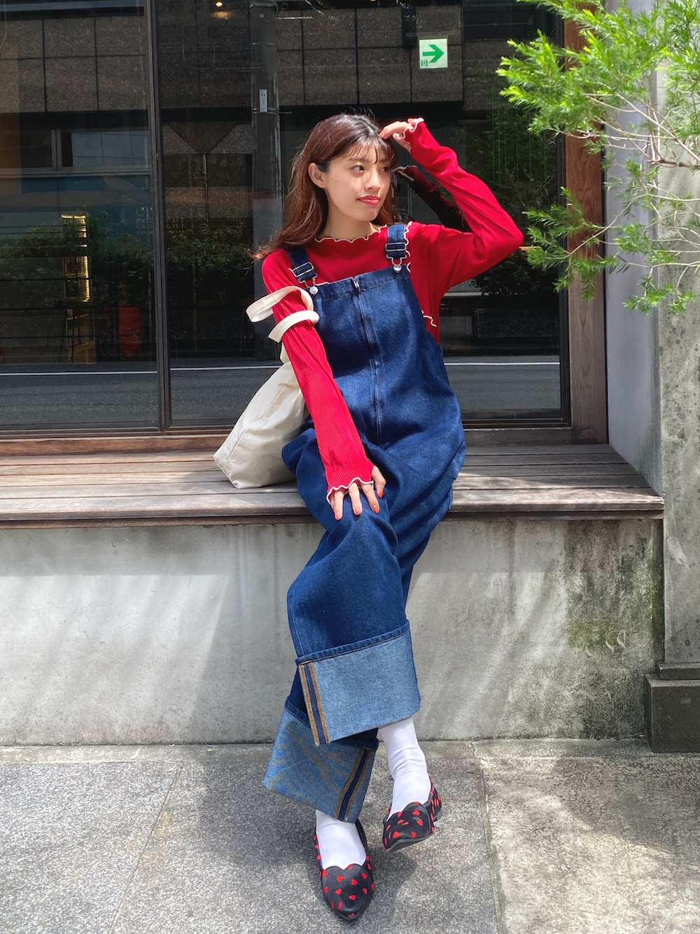 ブルー系のサロペット/オーバーオール、レッド系のTシャツ/カットソー、ブラック系のパンプスを着用したレディースの秋コーディネートの2枚目の写真