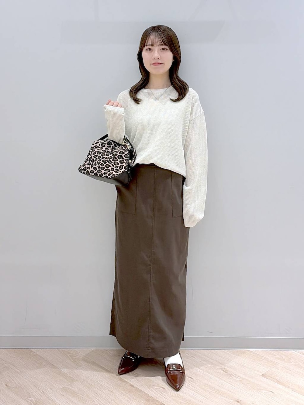 その他のショルダーバッグ、ブラウン系のスカート、ブラウン系のローファーを着用したレディースの春コーディネートの2枚目の写真