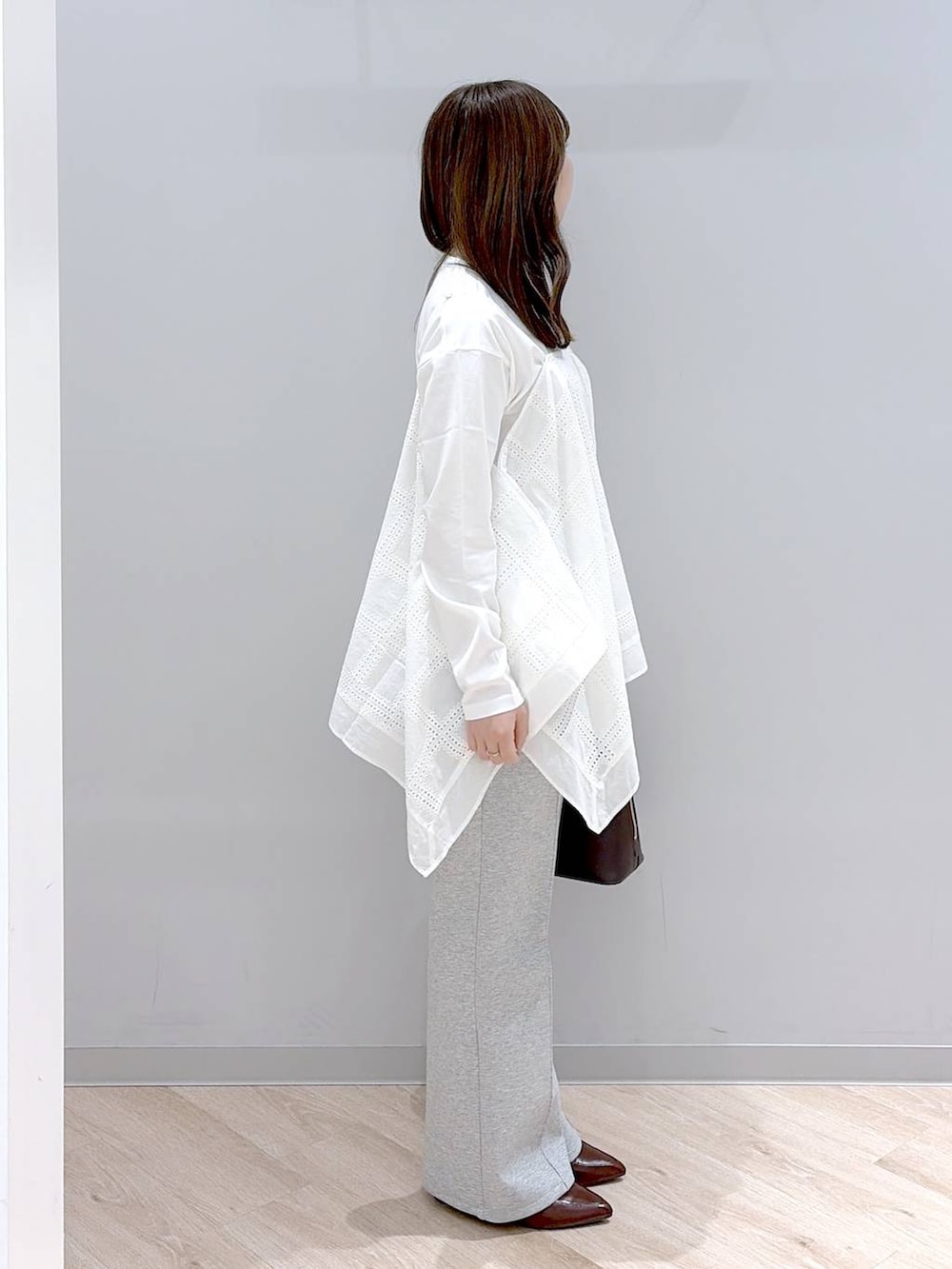 グレー系のスウェットパンツ、ホワイト系のTシャツ/カットソー、ブラウン系のローファーを着用したレディースの春コーディネートの3枚目の写真