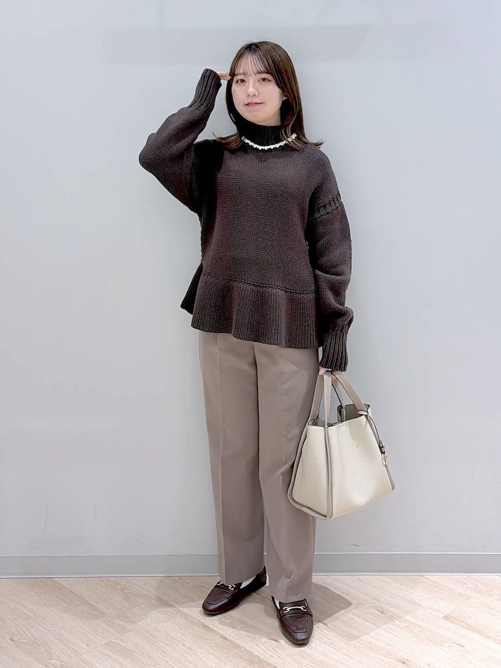 ブラウン系のローファー、ブラウン系のその他パンツ、ベージュ系のトートバッグを着用したレディースの冬コーディネートの2枚目の写真