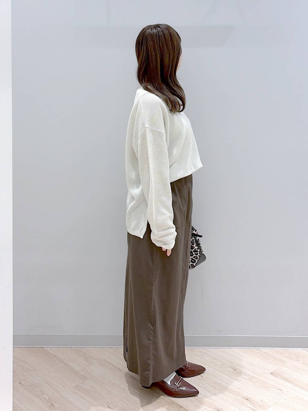 その他のショルダーバッグ、ブラウン系のスカート、ブラウン系のローファーを着用したレディースの春コーディネートの3枚目の写真