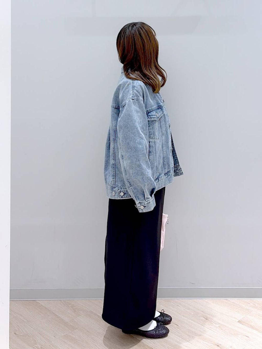 ブラック系のバレエシューズ、ピンク系のトートバッグ、ブルー系のデニムジャケットを着用したレディースの冬コーディネートの3枚目の写真