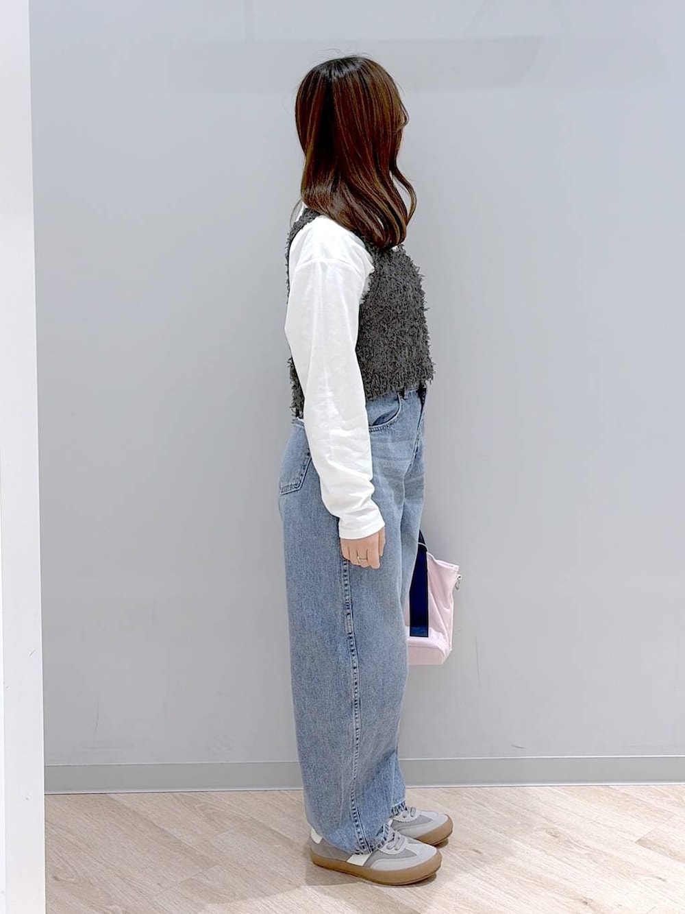 グレー系のスニーカー、ピンク系のトートバッグ、ホワイト系のTシャツ/カットソーを着用したレディースの冬コーディネートの3枚目の写真