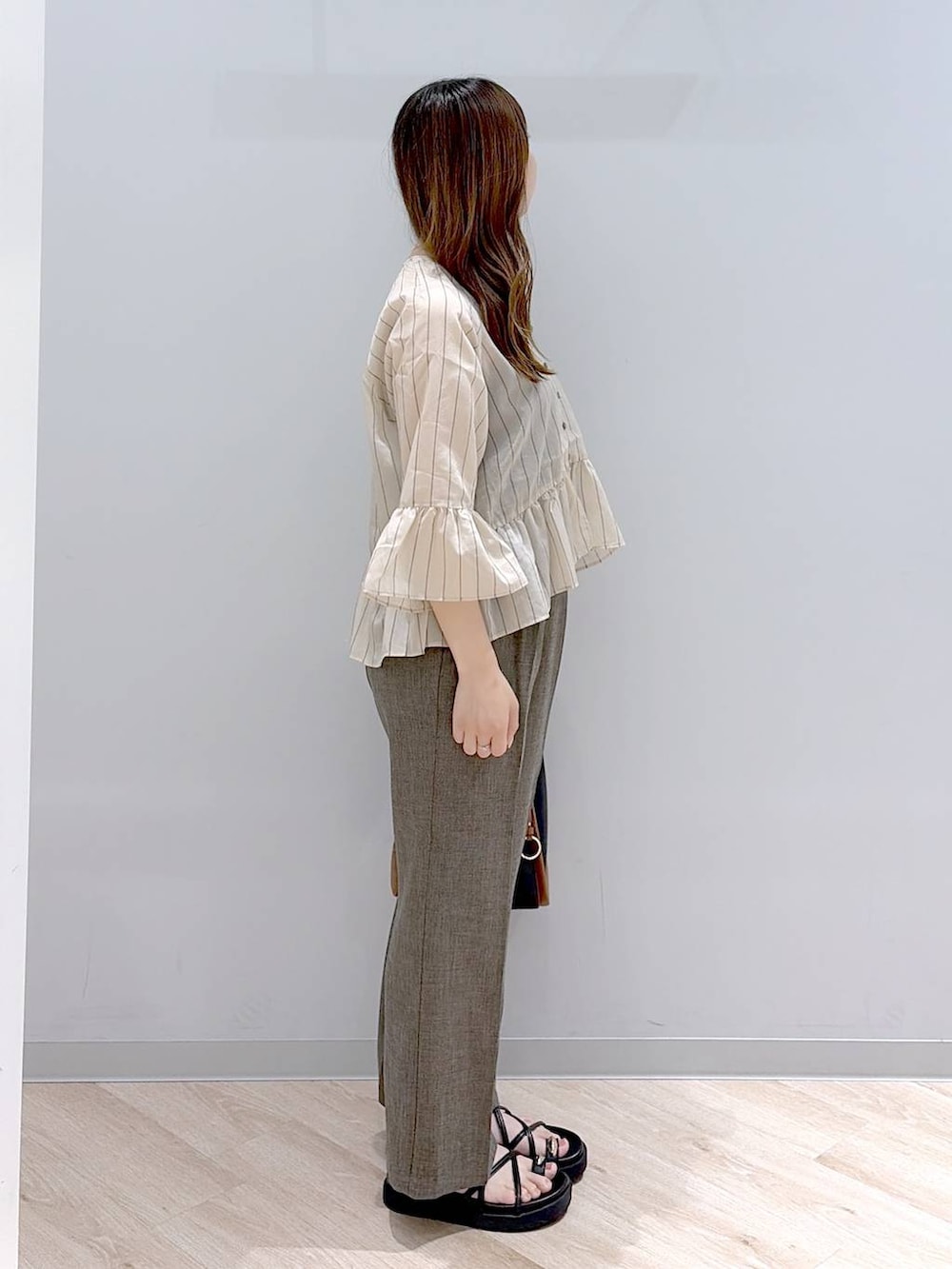 ブラック系のトートバッグ、ブラウン系のその他パンツ、ベージュ系のカーディガン/ボレロを着用したレディースの夏コーディネートの3枚目の写真