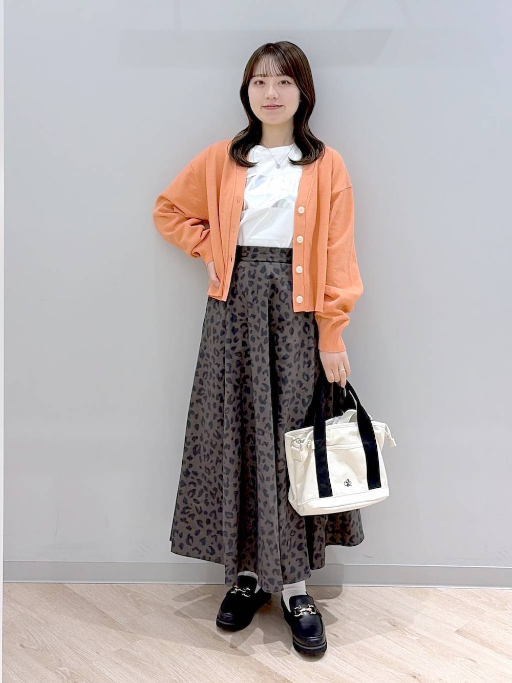 ブラック系のローファー、ホワイト系のトートバッグ、その他のスカートを着用したレディースの春コーディネートの2枚目の写真