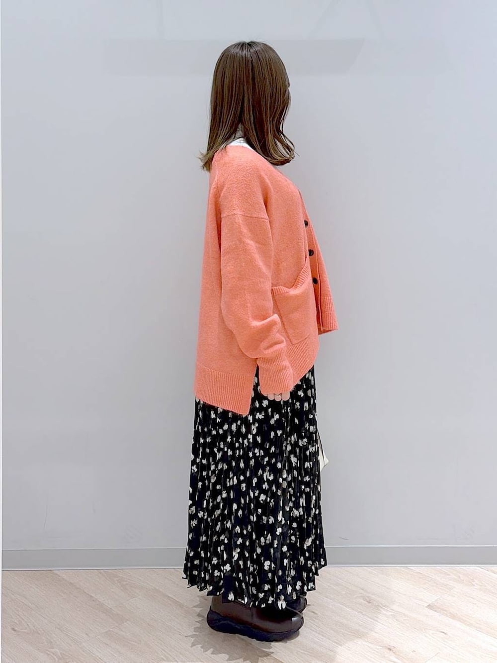 ホワイト系のショルダーバッグ、ピンク系のカーディガン/ボレロ、ホワイト系のTシャツ/カットソーを着用したレディースの冬コーディネートの3枚目の写真