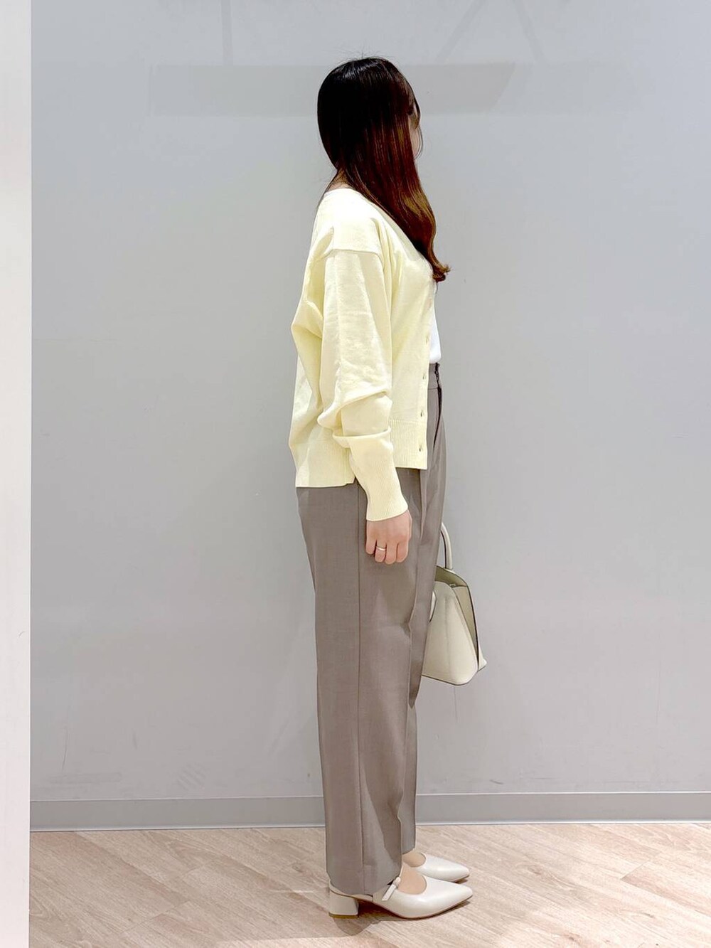 ホワイト系のショルダーバッグ、イエロー系のカーディガン/ボレロ、イエロー系のその他パンツを着用したレディースの春コーディネートの3枚目の写真