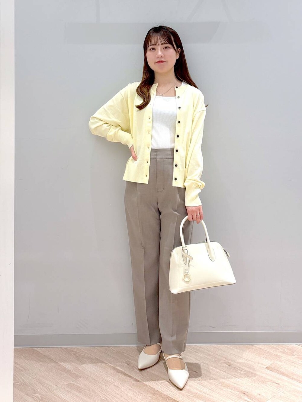 ホワイト系のショルダーバッグ、イエロー系のカーディガン/ボレロ、イエロー系のその他パンツを着用したレディースの春コーディネートの2枚目の写真