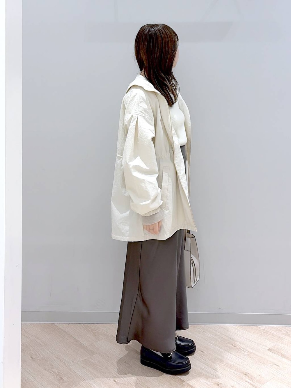 ブラック系のローファー、ホワイト系のショルダーバッグ、ブラウン系のスカートを着用したレディースの春コーディネートの3枚目の写真