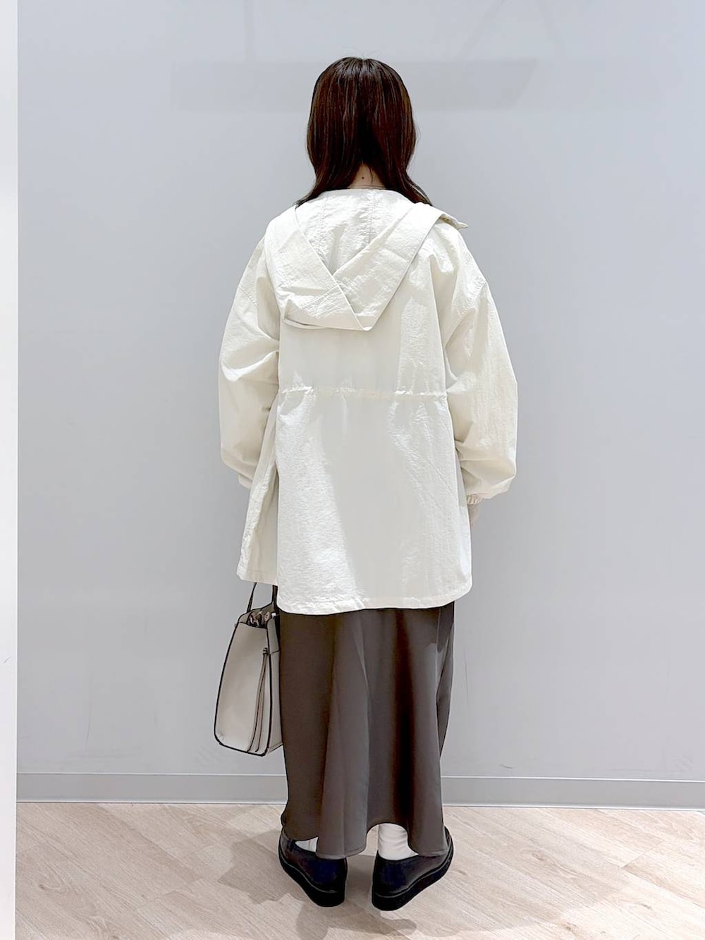 ブラック系のローファー、ホワイト系のショルダーバッグ、ブラウン系のスカートを着用したレディースの春コーディネートの4枚目の写真