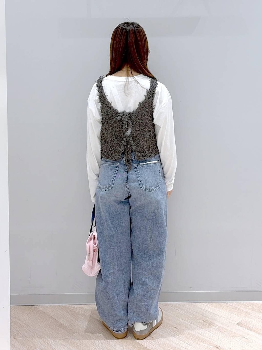 グレー系のスニーカー、ピンク系のトートバッグ、ホワイト系のTシャツ/カットソーを着用したレディースの冬コーディネートの4枚目の写真