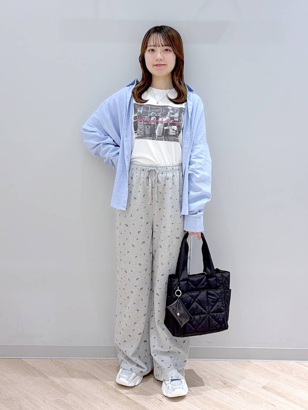 ブラック系のトートバッグ、ブルー系のシャツ/ブラウス、ホワイト系のTシャツ/カットソーを着用したレディースの春コーディネートの3枚目の写真