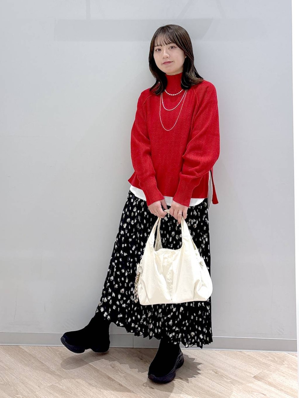 ホワイト系のTシャツ/カットソー、ブラック系のブーツ、レッド系のニット/セーターを着用したレディースの秋コーディネートの2枚目の写真