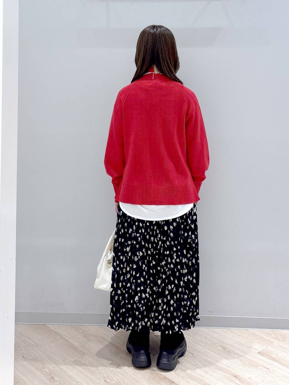 ホワイト系のTシャツ/カットソー、ブラック系のブーツ、レッド系のニット/セーターを着用したレディースの秋コーディネートの4枚目の写真