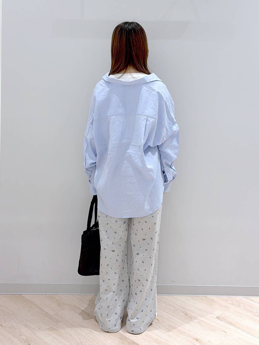 ブラック系のトートバッグ、ブルー系のシャツ/ブラウス、ホワイト系のTシャツ/カットソーを着用したレディースの春コーディネートの5枚目の写真