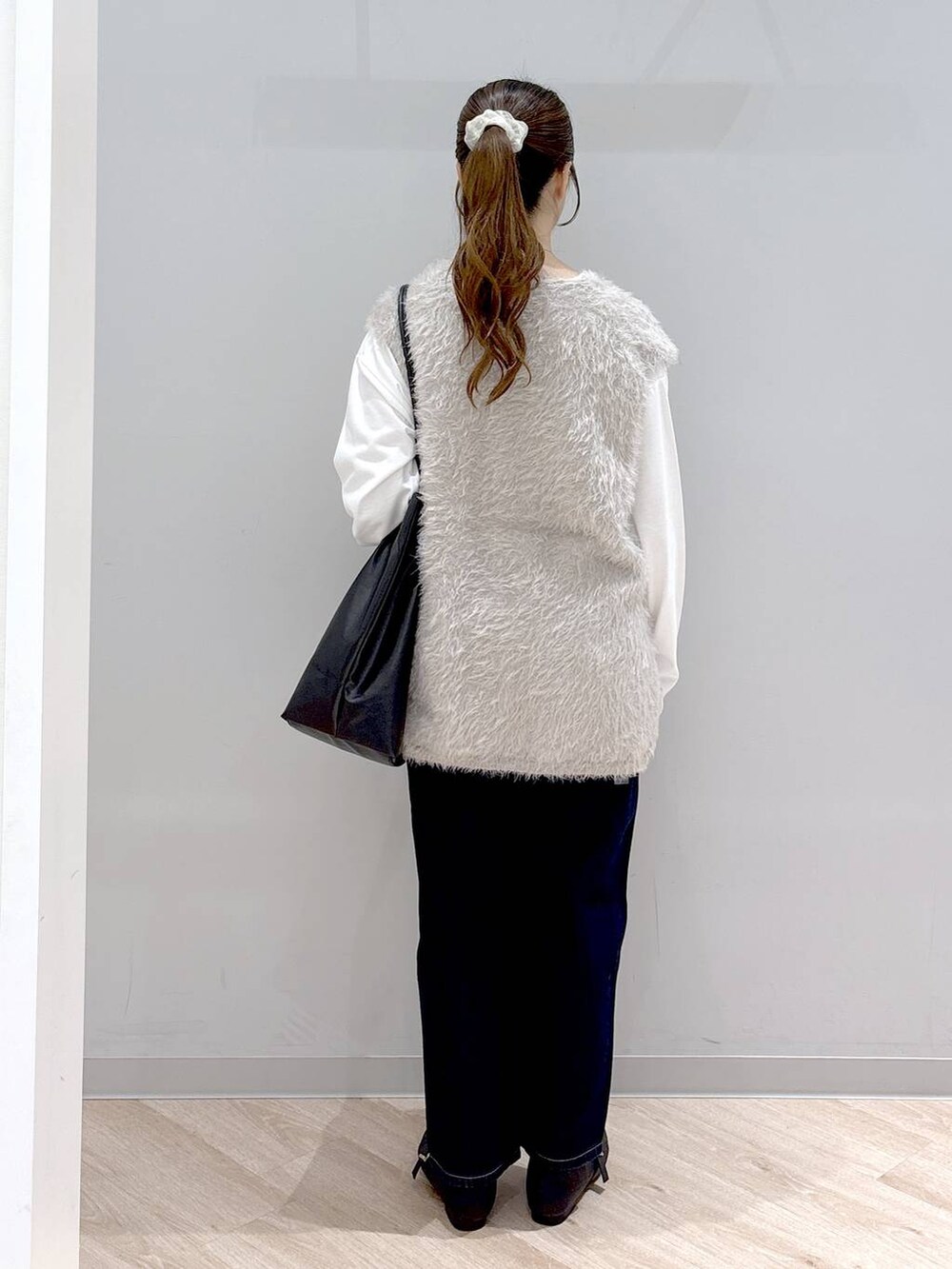 その他のパンプス、ブルー系のデニムパンツ、ベージュ系のベストを着用したレディースの秋コーディネートの4枚目の写真