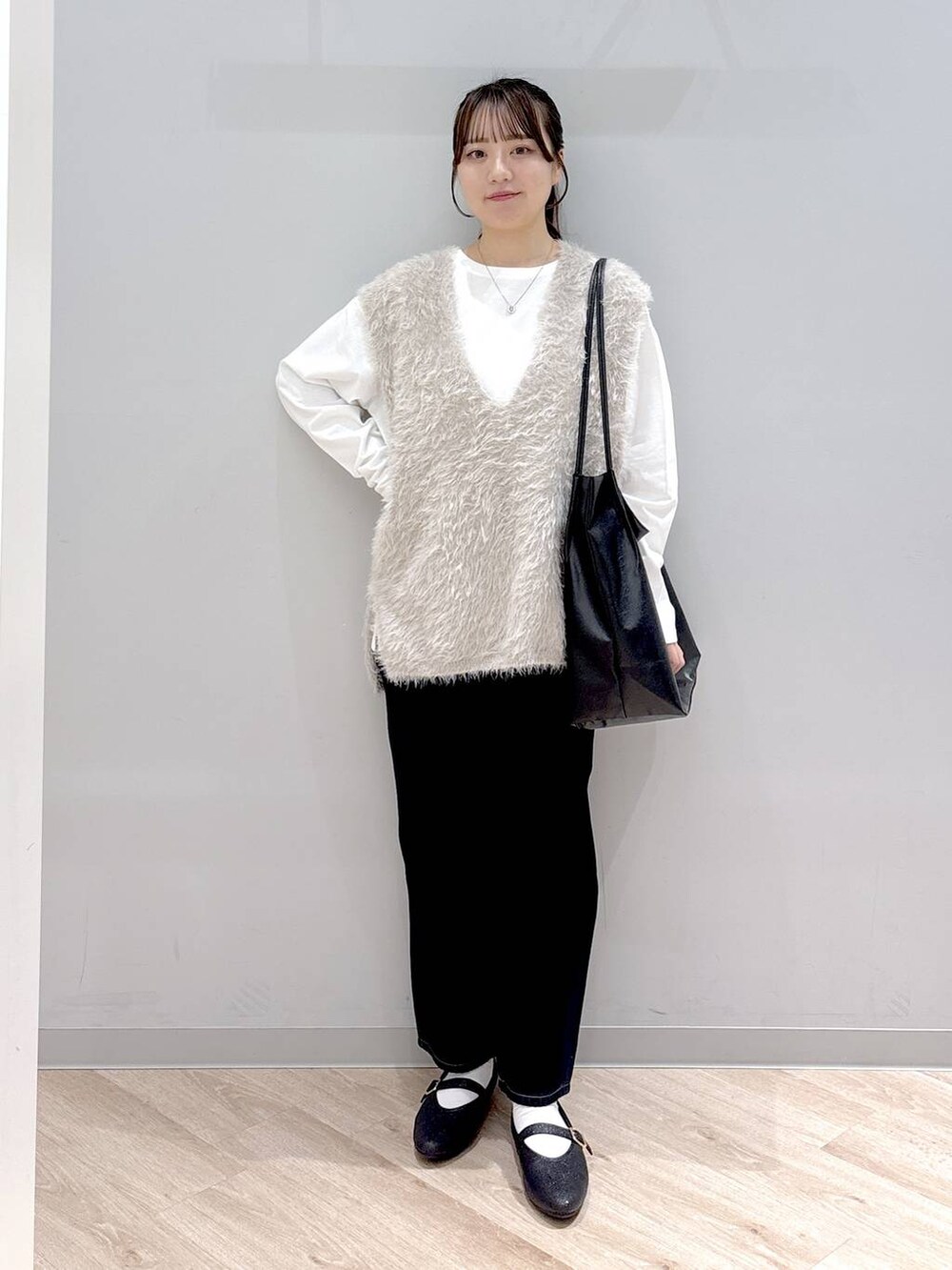 その他のパンプス、ブルー系のデニムパンツ、ベージュ系のベストを着用したレディースの秋コーディネートの2枚目の写真