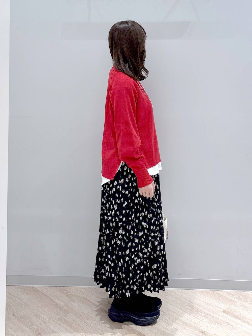 ホワイト系のTシャツ/カットソー、ブラック系のブーツ、レッド系のニット/セーターを着用したレディースの秋コーディネートの3枚目の写真